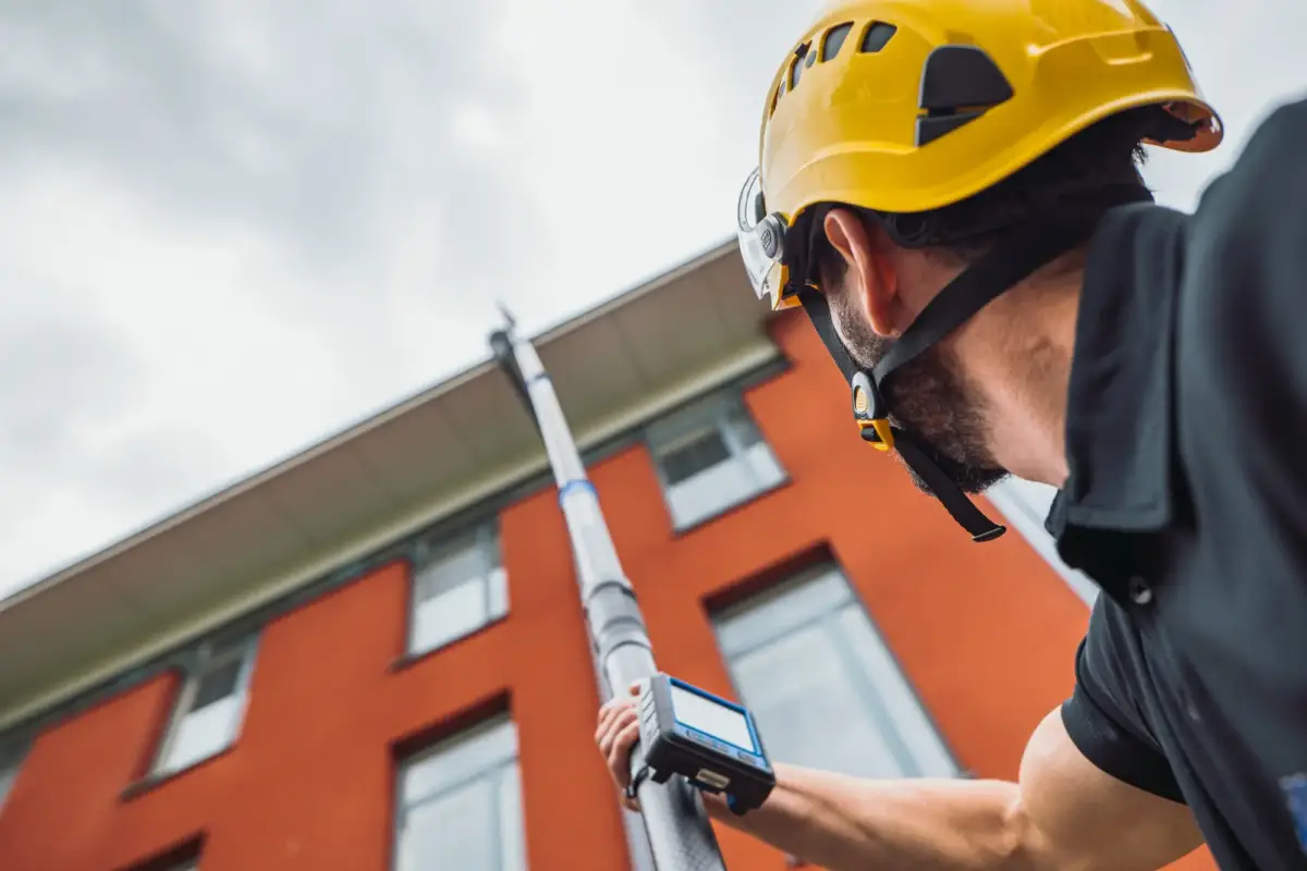 Mies imuroi kattoa teleskooppiputkella